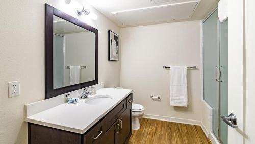 een badkamer met een wastafel, een spiegel en een toilet bij Landing Modern Apartment with Amazing Amenities (ID8283X49) in Englewood