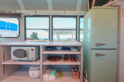a kitchen with a refrigerator and a microwave at Hotel Ocean BUS Shirahama in Shioura