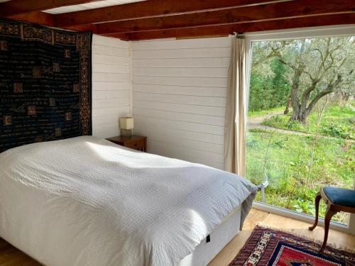 a bedroom with a bed and a large window at Lakeside Hideaway Cabin in Bursa