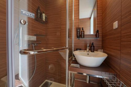 een badkamer met een wastafel en een douche bij Hotel Ocean BUS Shirahama in Shioura