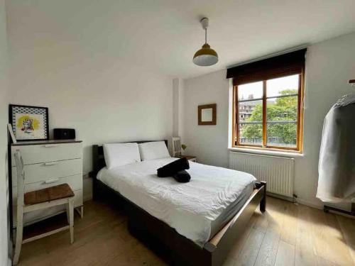 a bedroom with a bed with a black cat laying on it at Beautiful canal-view apartment in London