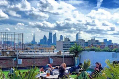 a group of people laying on a rooftop with a city skyline at Beautiful canal-view apartment in London