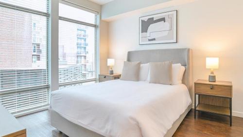 1 dormitorio con cama blanca y ventana grande en Landing Modern Apartment with Amazing Amenities (ID8092X98) en Orlando
