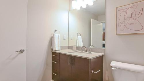 a bathroom with a sink and a toilet and a mirror at Landing Modern Apartment with Amazing Amenities (ID8092X98) in Orlando