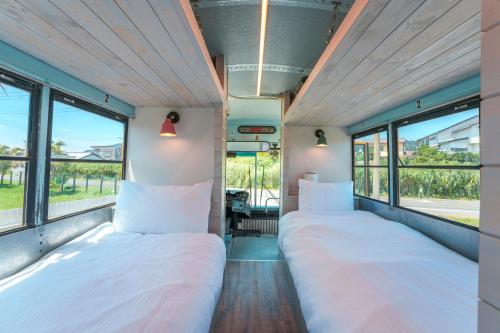 Dos camas en una habitación con ventanas. en Hotel Ocean BUS Shirahama, en Shioura