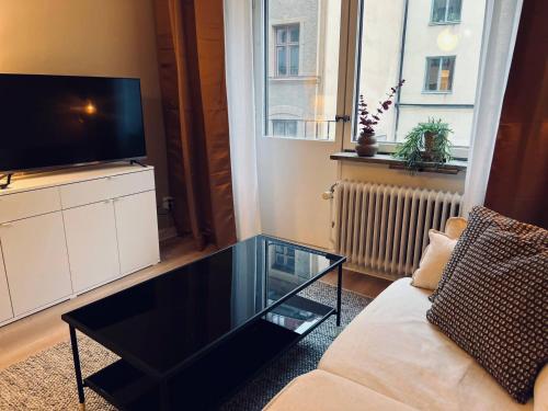 a living room with a glass coffee table and a television at Cozy one bedroom apartment in Stockholm in Stockholm
