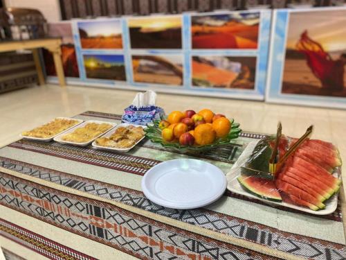 una mesa cubierta con platos de fruta y otros alimentos en Desert Life Camp en Wadi Rum