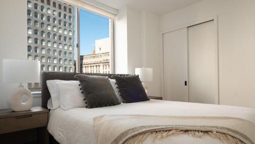 een slaapkamer met een bed en een groot raam bij Landing Modern Apartment with Amazing Amenities (ID3117X83) in New York