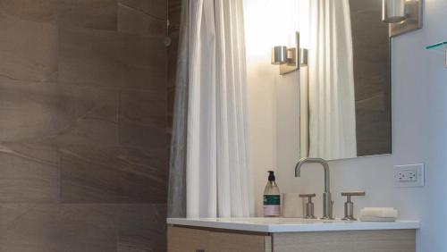 een badkamer met een wastafel en een douche met een spiegel bij Landing Modern Apartment with Amazing Amenities (ID3117X83) in New York