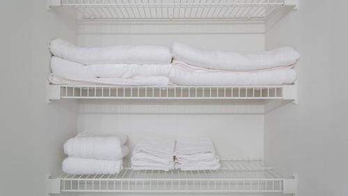 a closet filled with lots of white towels on shelves at Landing Modern Apartment with Amazing Amenities (ID7433X30) in Indianapolis