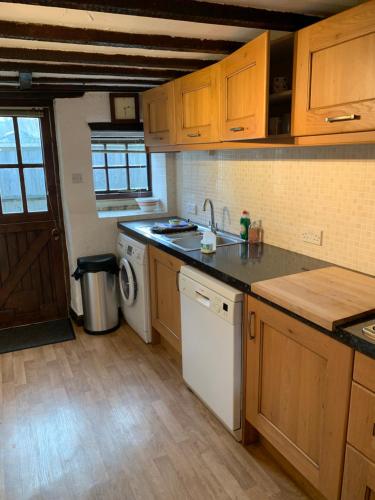 eine Küche mit Spüle und Geschirrspüler in der Unterkunft Superbly appointed 300 year old stone cottage in Bakewell