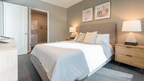 ein Schlafzimmer mit einem großen weißen Bett und einem Nachttisch in der Unterkunft Landing Modern Apartment with Amazing Amenities (ID5151X99) in Tower Grove