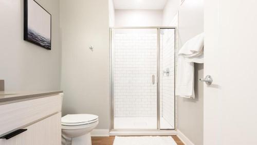 ein weißes Bad mit einem WC und einer Dusche in der Unterkunft Landing Modern Apartment with Amazing Amenities (ID5151X99) in Tower Grove