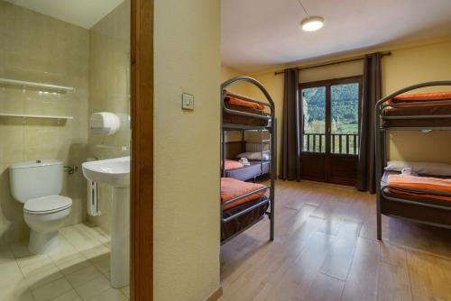 a room with a bathroom with a sink and bunk beds at Albergue Villanúa in Villanúa