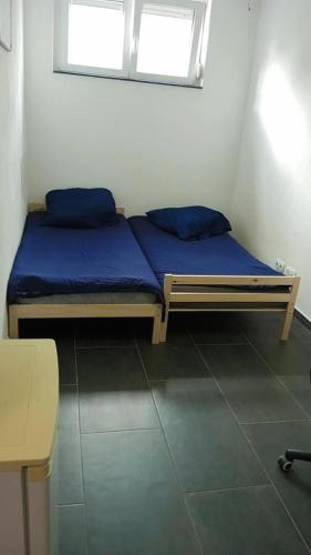 een bed met blauwe lakens in een kamer met een raam bij Nina Zimmer in Heilbronn Zentrum in Heilbronn