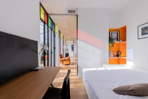 une chambre avec un lit et un bureau avec une télévision dans l'établissement Terrasse de Bellecour - Lyon 2 Plein Centre, à Lyon