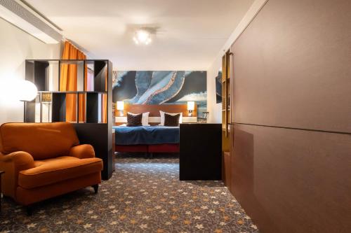 Habitación con 1 cama, 1 silla y 1 dormitorio. en ProfilHotels Opera, en Gotemburgo