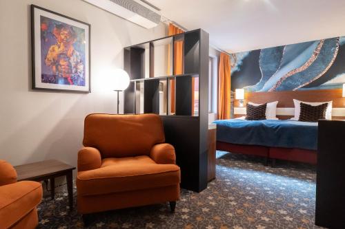 a hotel room with a chair and a bed at ProfilHotels Opera in Gothenburg