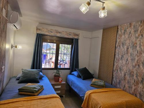 een slaapkamer met 2 bedden en een raam bij Casa Veintiuno en Calp in Calpe