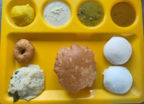 a yellow tray with different types of food on it at Rithikha Inn Crest in Chennai