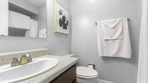 bagno bianco con lavandino e servizi igienici di Landing Modern Apartment with Amazing Amenities (ID7684X1) a Lexington