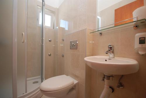 uma casa de banho com um WC, um lavatório e um chuveiro em Pansion Anita em Budva