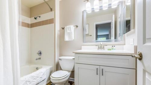 Baño blanco con lavabo y aseo en Landing Modern Apartment with Amazing Amenities (ID4377X11), en Naperville