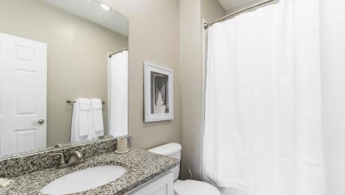 a bathroom with a sink and a toilet and a mirror at Landing Modern Apartment with Amazing Amenities (ID1007X548) in Jacksonville