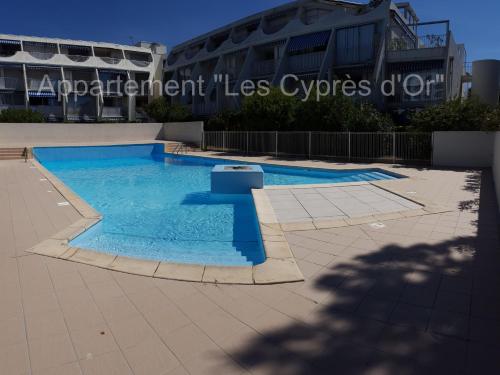une piscine devant un immeuble dans l'établissement Les Cyprès d'Or, à La Grande Motte