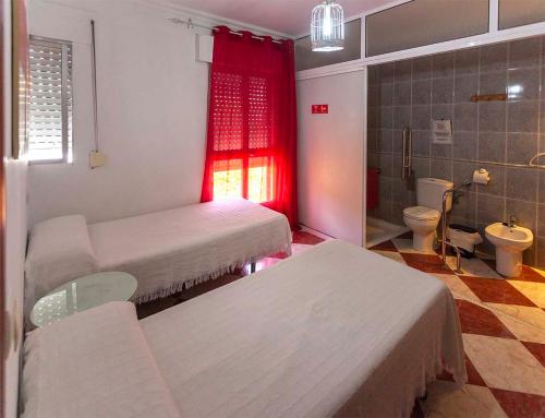 a hospital room with two beds and a bathroom at Pension Hidalgo 1 in Utrera