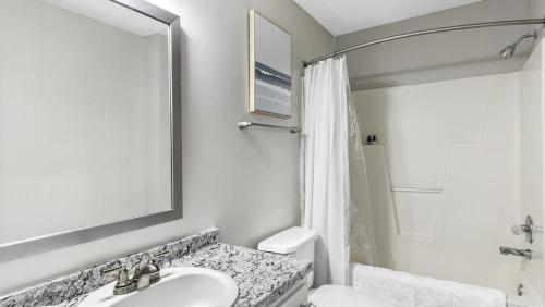 Landing Modern Apartment with Amazing Amenities (ID1248X358) في دورهام: حمام أبيض مع حوض ومرآة