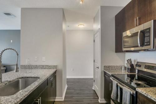 a kitchen with a sink and a microwave at Landing Modern Apartment with Amazing Amenities (ID5692X84) in Tampa