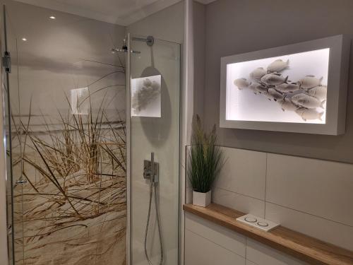 een badkamer met een douche en een foto aan de muur bij Apartment 76 im Haus Villa Anna II in Sankt Peter-Ording