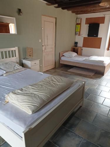 Un dormitorio con 2 camas y una puerta. en Chambre triple, en Thorigné-sur-Dué