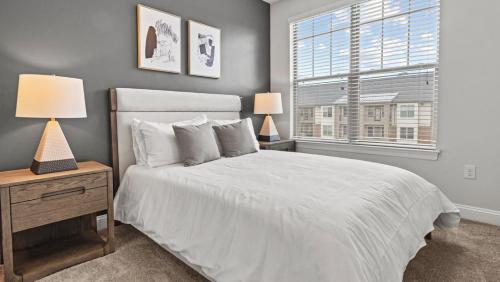 a bedroom with a white bed and a window at Landing Modern Apartment with Amazing Amenities (ID8773X70) in Matthews