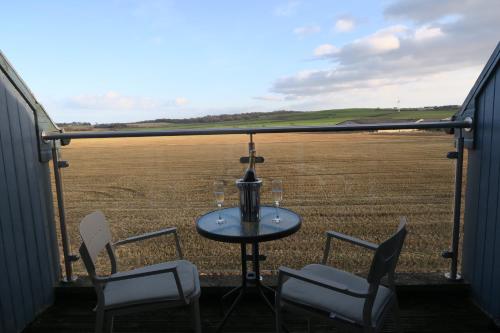 a table and chairs with a view of a field at The Inn At Lathones in St. Andrews