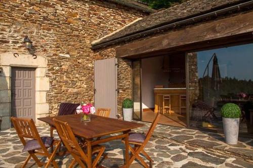 une table et des chaises en bois sur une terrasse dans l'établissement Mas de l'Ayrolle - Mas en Cévennes, à Génolhac