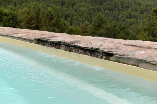 une grande masse d'eau avec des arbres à l'arrière-plan dans l'établissement Mas de l'Ayrolle - Mas en Cévennes, à Génolhac