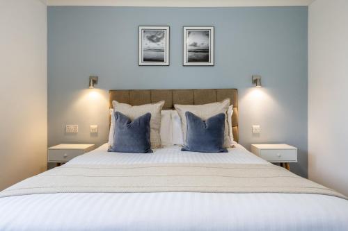 a bedroom with a large bed with blue pillows at Inn For All Seasons in Redruth