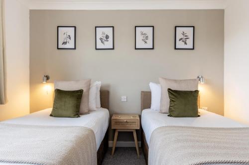two beds sitting next to each other in a room at Inn For All Seasons in Redruth
