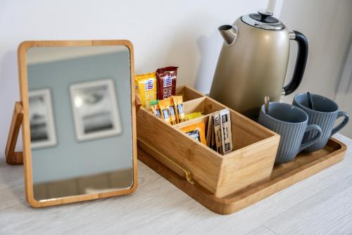 a wooden tray with a mirror and a tea kettle at Inn For All Seasons in Redruth