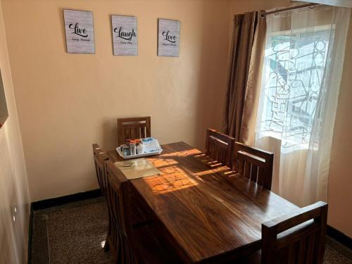 mesa de comedor con sillas, mesa y ventana en Kiota Cha Mama, en Busia