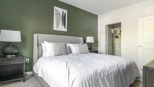 ein Schlafzimmer mit einem Bett und einer grünen Wand in der Unterkunft Landing Modern Apartment with Amazing Amenities (ID9264X04) in Largo