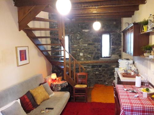 a living room with a couch and a stone wall at Cozy Mountain Villa in P. Agios Athanasios in Palaios Agios Athanasios