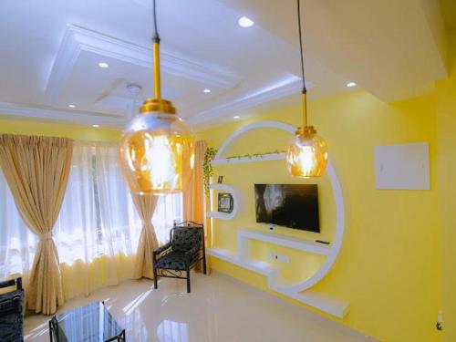a living room with a tv on a yellow wall at Beachside Bliss Apartment in Colva Salcette- Goa in Colva