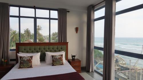 a bedroom with a bed with a view of the ocean at Surf view resort in Ahangama