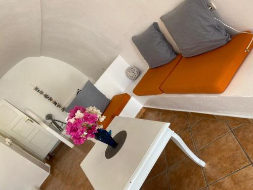 a small room with a bed and a table with flowers at Palm Tree Hill in Oia