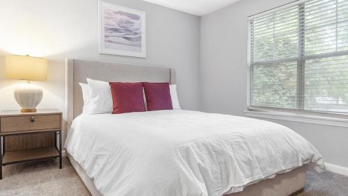 um quarto branco com uma cama e uma janela em Landing Modern Apartment with Amazing Amenities (ID9623X55) em Durham