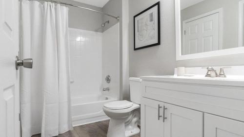 uma casa de banho branca com um WC e um lavatório em Landing Modern Apartment with Amazing Amenities (ID9623X55) em Durham