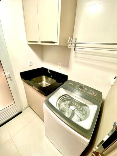 a washing machine in a kitchen with a sink at Apto em Navegantes/Gravatá in Navegantes